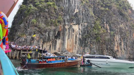 Boat-with-tourists-arriving-to-Maya-Bay-pier-in-Phi-Phi-islands,-Thailand