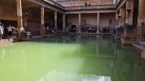 Historisches-Gebäude-In-Bath,-England-Mit-Touristen-Und-Video,-Das-In-Zeitlupe-Nach-Oben-Schwenkt