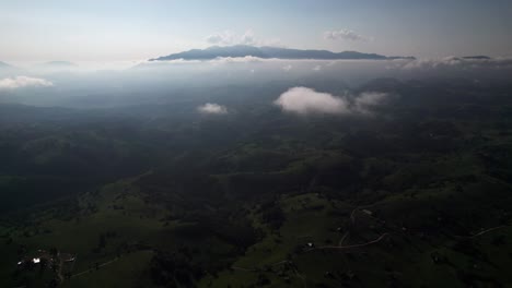 Luftaufnahme-Von-Nebligen-Hügeln-Und-Vereinzelten-Wolken-Am-Frühen-Morgen-Mit-Blick-Auf-Erwachende-Täler