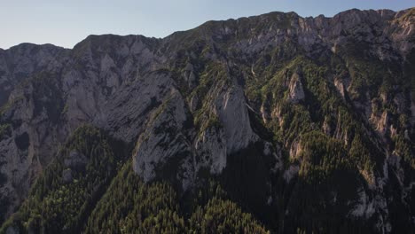 Majestätische-Piatra-Craiului-Berge-Mit-Dichten-Wäldern-Und-Schroffen-Klippen-Bei-Sonnenuntergang,-Luftaufnahme