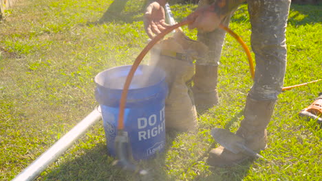 Volcar-La-Mezcla-De-Concreto-En-Un-Balde-Y-Agregar-Agua,-Dispositivo-Portátil-De-ángulo-Bajo