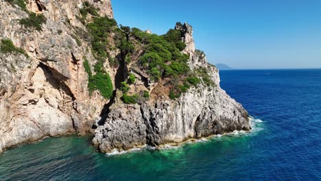 Cliffside-view-on-Corfu-Island-with-lush-greenery-overlooking-the-Ionic-Sea-under-a-clear-blue-sky