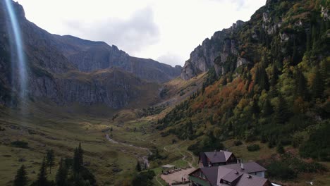 Autumnal-mountain-landscape-with-cozy-chalet-in-Bucegi,-aerial-view