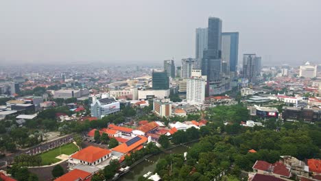 In-the-heart-of-Surabaya-city,-a-majestic-skyscraper,-one-of-Indonesia's-largest-malls-amidst-the-urban-bustle-and-surrounded-by-green-space,Harmonizing-urbanization,-modernity,-and-sustainability