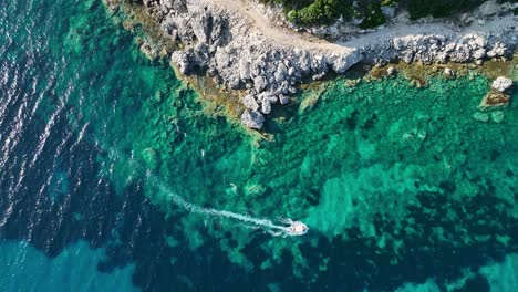 Ein-Boot,-Das-Durch-Das-Kristallklare-Wasser-In-Der-Nähe-Der-Insel-Korfu-Schneidet,-Heller-Tag,-Luftaufnahme