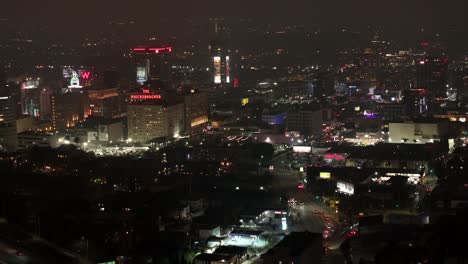 Establishing-view-of-Hollywood,-California-on-foggy-night---ascending-aerial-reveal