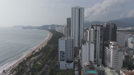 A-breathtaking-drone-view-of-Nha-Trang's-skyline,-where-fluffy-clouds-drift-above-the-city's-architectural-gems
