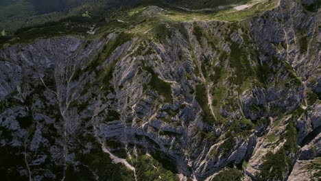 The-rugged-piatra-craiului-mountains-under-bright-sunlight,-highlighting-textures,-aerial-view