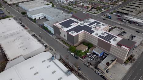 Aerial-Drone-Flyover-Industrial-Solar-Panel-Cells-On-Commercial-Building-Rooftop