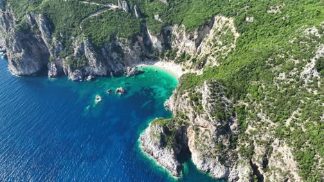 Giali-beach-on-corfu-island-with-turquoise-waters-and-rugged-cliffs,-sunny-day,-aerial-view