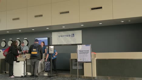 People-at-United-Airlines-Check-In-at-North-Bend-Airport,-panning-shot