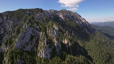 Die-Majestätischen-Piatra-Craiului-Berge-Unter-Klarem-Blauen-Himmel,-üppige-Wälder-Im-Hintergrund,-Luftaufnahme