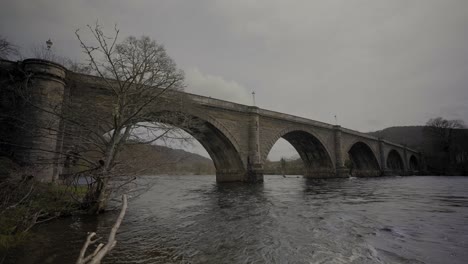 Gente-Caminando-Sobre-El-Puente-Dunkeld-En-Escocia