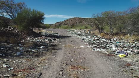Garbage-Along-the-Roadside-Detracting-From-the-Desert-Landscape-of-Mulege,-Baja-California-Sur,-Mexico---Drone-Flying-Forward