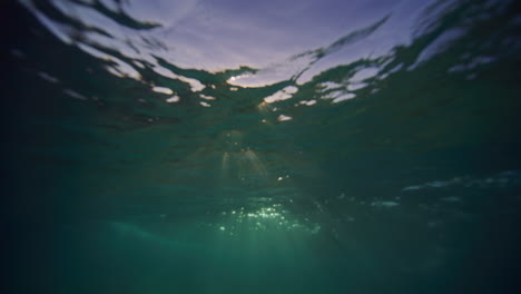 Los-Rayos-De-Luz-Blanca-Brillan-Y-Brillan-Mientras-El-Agua-Del-Océano-Forma-Una-Ola-Sobre-La-Arena.