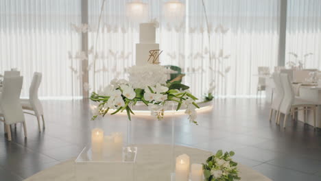 Luxurious-wedding-reception-setup-with-elegant-floral-centerpiece-and-towering-cake