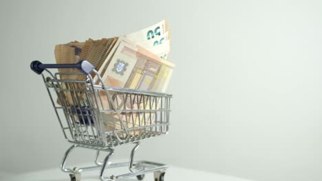 Carrito-De-Compras-Con-Billete-De-50-Euros,-Dinero-Dentro-Del-Negocio-Que-Fluye,-Concepto-De-Estudio-De-Efectivo