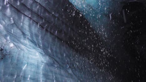 Water-dripping-from-inside-a-dark-glacial-ice-cave-in-Iceland---Slow-motion