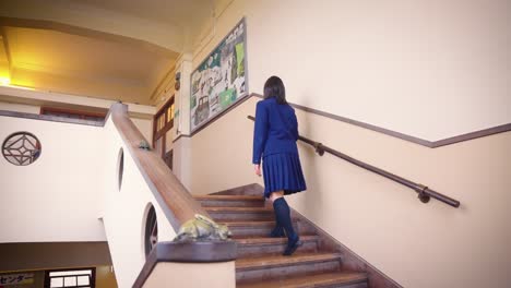 Una-Chica-Con-Uniforme-Escolar-Sube-Lentamente-Las-Escaleras-Entre-Clases