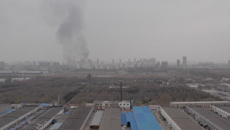 Huge-plumes-of-smoke-are-visible-on-the-horizon-near-the-industrial-zone-in-Tianjin,-China