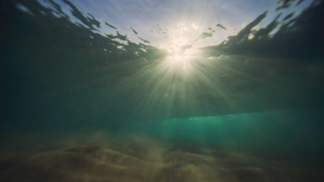 Funkelnder-Lichtstrahl-Unter-Wasser-In-Der-Mitte,-Als-Die-Welle-Bricht