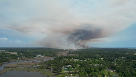 Wide-drone-shot-of-a-forest-fire,-panning-from-right-to-left