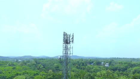 Telecommunication-tower-with-5G-cellular-network-antenna-on-green-trees-background
