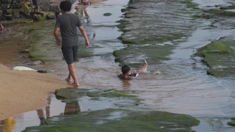Kinder-Schwimmen-Am-Strand,-Flaches-Wasser,-Moosige-Felsen,-Galface,-Colombo
