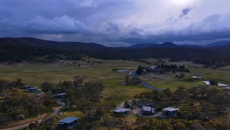 Dark-storm-clouds-above-Kosciuszko-National-Park-mountain-ranges-with-Crakenback-town-in-foreground,-New-South-Wales,-Australia
