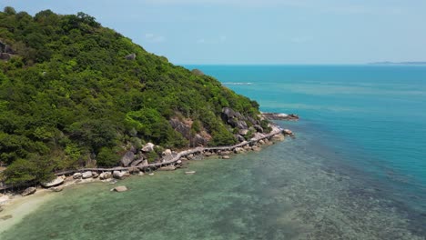 Drone-flight-over-beach-with-wooden-path-walking-around-island