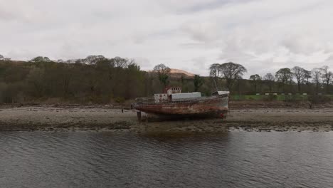 Static-shot-of-a-group-of-tourists-exploring-the-Corpach-Shipwreck-landmark