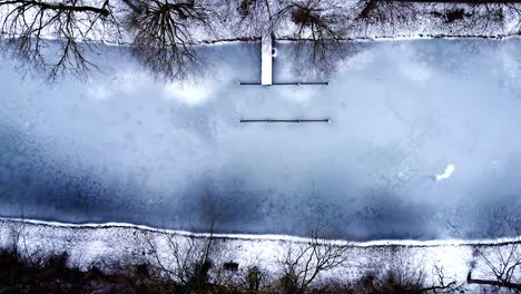 Lago-Congelado-En-El-Bosque-Drone-Cinematográfico-De-Arriba-Hacia-Abajo