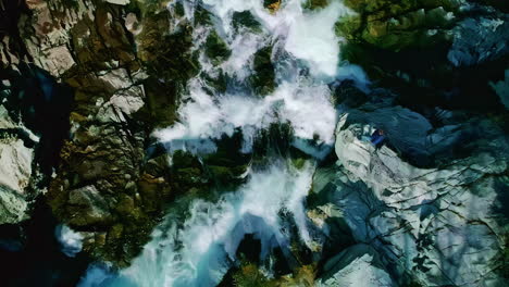 Waterfall-tumbling-down-a-mountainside-in-Norway---straight-down-ascending-aerial