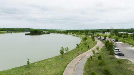 Shelby-farms-park,-memphis,-with-a-serene-lake,-greenery,-and-a-walking-path,-aerial-view