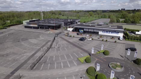 Ascending-aerial-showing-Gazelle-experience-center-parking-lot-for-bicycle-trial-and-try-out-facility