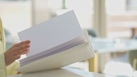 A-woman-siting-on-a-table-in-the-living-room-with-her-book-and-drink,-close-up-shot,-push-in-shot