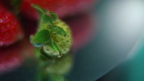 Macro-detailed-video-of-a-pile-of-strawberries,-tiny-green-RAW-strawberry,-on-a-rotating-stand,-smooth-movement,-slow-motion-120fps
