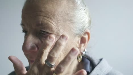 slow-motion-portrait-elder-senior-woman-applies-herself-white-cream-make-up-wrinkles-ageing-concept