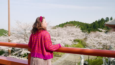 Mujer-Europea-Admirando-Las-Hermosas-Flores-De-Cerezo-En-El-Templo-Tsubosakadera-En-Japón.