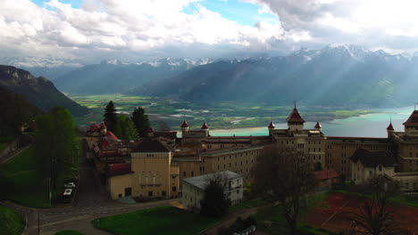 Caux-Palace-in-Switzerland,-aerial-overlooking-the-Geneva-Lake,-Valley-and-Alps