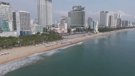 An-immersive-aerial-panorama-revealing-the-charm-of-Nha-Trang's-skyline,-with-wispy-clouds-adding-a-touch-of-drama-to-the-cityscape-as-traffic-flows-gracefully-below