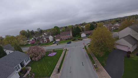 Aerial-FPV-over-housing-area-with-homes-and-buildings-during-cloudy-day-in-Spring
