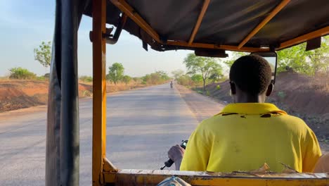 Taxi-Rickshaw-Conduciendo-Por-La-Carretera-En-La-Remota-Aldea-Rural-De-Wulugu,-En-El-Norte-De-Ghana