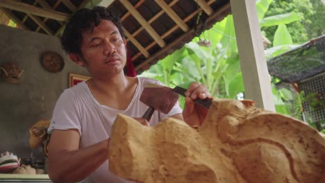 Balinesischer-Holzschnitzer-Mit-Hammer-Und-Meißel-Macht-Traditionelle-Barong-Maske-In-Bali,-Indonesien