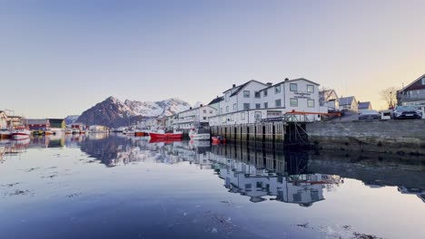 Ruhiger-Wintermorgen-Auf-Den-Lofoten-Mit-Spiegelung-Von-Häusern-Und-Booten-Im-Wasser,-Klarer-Himmel