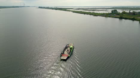 Ferry-sails-in-the-middle-of-the-river,-flag-at-half-mast-in-connection-with-Remembrance-Day