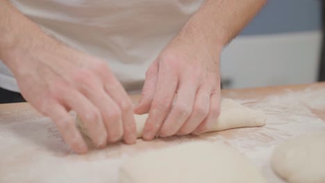 Baker-preparing-fresh-dough-for-baguette,-hands-close-up