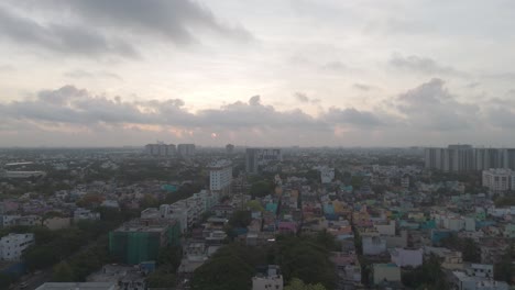 An-immersive-aerial-perspective-of-Chennai's-urban-landscape,-showcasing-the-bustling-city-life-and-architectural-diversity-amidst-a-cloudy-sky