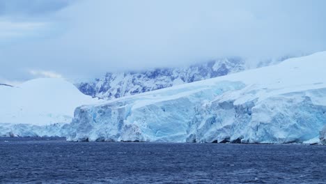 Glacier-and-Ocean-in-Antarctica-on-the-Coast,-Ice-and-Coastal-Winter-Scenery,-Icy-Glacial-Landscape-with-a-Large-Glacier-Next-to-the-Sea-on-the-Antarctic-Peninsula-with-a-Crevass-and-Ice-Formations