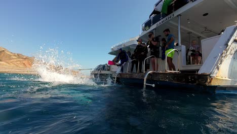 Scuba-Diver-Jumping-Off-The-Water-From-The-Boat-In-Dahab,-Egypt